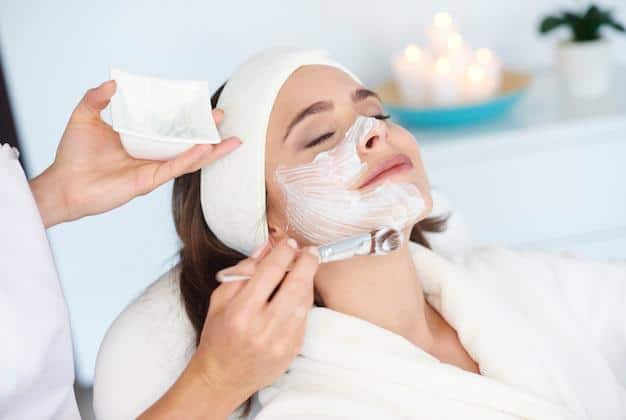 A woman relaxing during a facial treatment tailored to her skin type